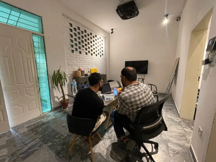 Two people working at laptops and desks in the STEM workspace
